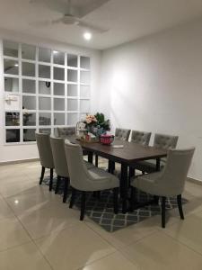 uma sala de jantar com uma mesa de madeira e cadeiras em Homestay Ruma Melaka em Malaca