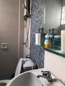 uma casa de banho com um lavatório, um WC e um espelho. em Homestay Ruma Melaka em Malaca