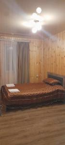 a large bed in a room with wooden walls at Marekhi guest house in Sagarejo
