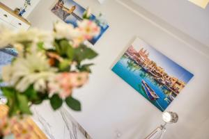 a table with flowers and a picture on it at Bluebell Apartment in Sliema in Sliema