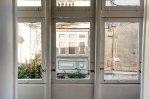 a door with three windows in a building at Bluebell Apartment-Hosted by Sweetstay in Sliema