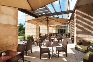 un patio al aire libre con mesas, sillas y sombrillas en The Westin Austin at The Domain en Austin