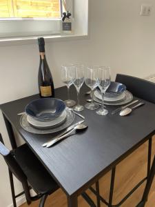 uma mesa com pratos e copos e uma garrafa de vinho em L agréable em Saint-Julien-les-Villas