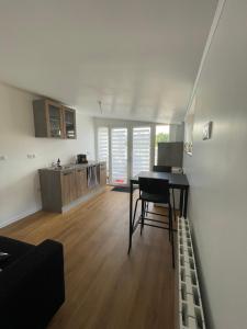 sala de estar con escritorio y cocina en L agréable en Saint-Julien-les-Villas