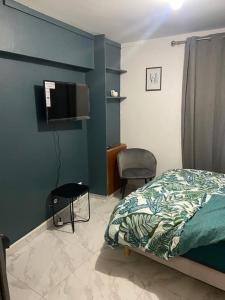 - une chambre avec un lit et une télévision à écran plat dans l'établissement Charmant Studio dans maison, à Sarcelles