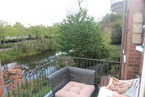 een balkon met een bank en uitzicht op een rivier bij Nordhörnchen! Sehr zentral, trotzdem ruhig! in Nordhorn