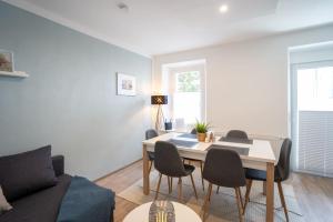 een woonkamer met een eettafel en stoelen bij nice2be Apartments - Lions Love in Augsburg