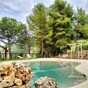 una piscina en un patio con árboles en Colle Serrano Relais & SPA, en Ripatransone