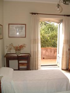 a bedroom with a white bed and a window at B&B Valle Allegra in Gravina di Catania