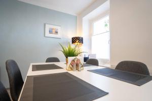 een vergaderruimte met een tafel met stoelen en een lamp bij nice2be Apartments - Lions Love in Augsburg