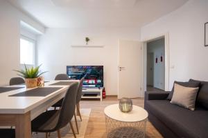 een woonkamer met een bank en een tafel bij nice2be Apartments - Lions Love in Augsburg