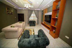 a living room with a couch and a tv at 3 bedrooms, Entire Flat, Amasaman - Accra in Amasaman