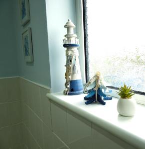 a window sill with a lighthouse and a toy on it at Butland House in Pembrokeshire