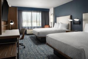 a hotel room with two beds and a desk at Courtyard by Marriott San Diego Mission Valley/Hotel Circle in San Diego