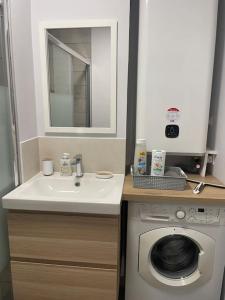 een badkamer met een wastafel en een wasmachine bij Appartement calme, climatisé 3min à pied de la mer in Palavas-les-Flots