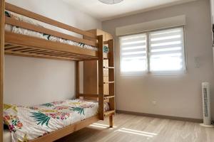 - une chambre avec 2 lits superposés et une fenêtre dans l'établissement Appartement calme, climatisé 3min à pied de la mer, à Palavas-les-Flots
