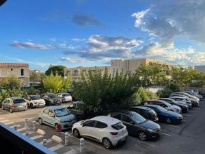 rząd samochodów zaparkowanych na parkingu w obiekcie Appartement calme, climatisé 3min à pied de la mer w mieście Palavas-les-Flots