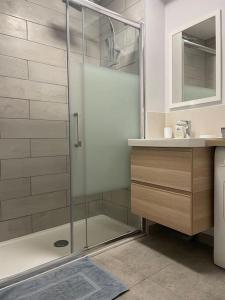 La salle de bains est pourvue d'une douche en verre et d'un lavabo. dans l'établissement Appartement calme, climatisé 3min à pied de la mer, à Palavas-les-Flots