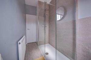 a bathroom with a shower with a glass door at Glasswing Stays Liquorice Lodge in Castleford +29 photos