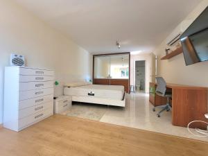 a bedroom with a bed and a desk and a tv at La Marina in Lloret de Mar
