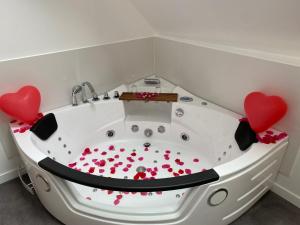 una bañera blanca con corazones rojos. en Le Cocon des Remparts-Logis Élégant à Pierrefonds, en Pierrefonds