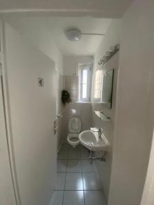 a white bathroom with a toilet and a sink at Chic & Trendy Mainz Apartment near cetral station in Mainz