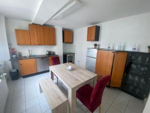 a kitchen with a wooden table and red chairs at Chic & Trendy Mainz Apartment near cetral station in Mainz