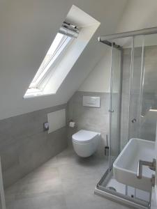 a bathroom with a toilet and a sink and skylight at Seaside-Amrum-16 in Norddorf