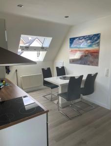 een keuken en eetkamer met een tafel en stoelen bij Seaside-Amrum-16 in Norddorf