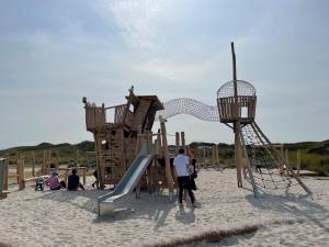 a group of people playing on a playground in the sand at Seaside-Amrum-16 in Norddorf