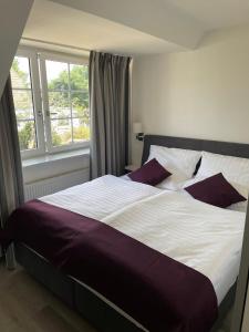 a large bed in a bedroom with a window at Seaside-Amrum-15 in Norddorf