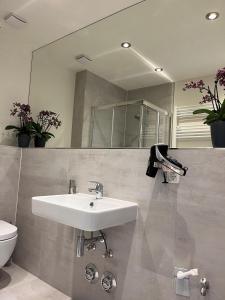 a bathroom with a sink and a mirror and a toilet at Seaside-Amrum-15 in Norddorf