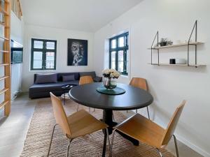 uma sala de estar com uma mesa e cadeiras e um sofá em Vibrant apartment on bustling street, above a restaurant Perfect for tourists, em Stavanger