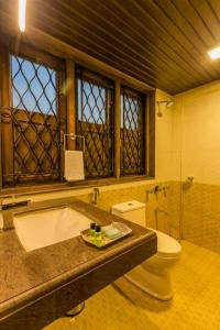 a bathroom with a bath tub and a toilet at Greenfield Resort, Matheran in Matheran