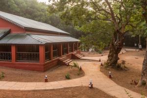 a red building with a tree in front of it at matheran Green field Resorts in Matheran +29 photos