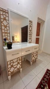 La salle de bains est pourvue d'un miroir et d'une commode blanche. dans l'établissement New Furnished Apartment, à Djibouti