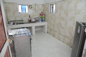a small kitchen with a sink and a tiled floor at New Furnished Apartment in Djibouti