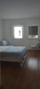 een witte slaapkamer met een bed en 2 ramen bij Zambujeiraseahouse - 100m da praia in Zambujeira do Mar