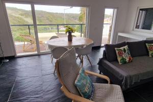 a living room with a table and a couch at Zambujeiraseahouse - 100m da praia in Zambujeira do Mar
