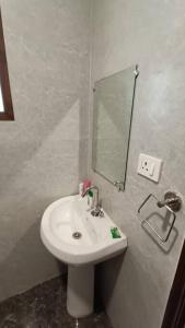 a bathroom with a white sink and a mirror at 85 The Ganges 2 BHK Apartment for Homestay in Rishīkesh
