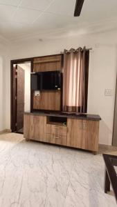 a room with a wooden cabinet with a microwave at 85 The Ganges 2 BHK Apartment for Homestay in Rishīkesh