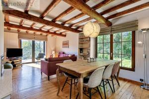 a kitchen and living room with a wooden table and chairs at Chalet 2 chambres "The Escape Chalet" by FineNest in Esneux