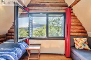 a room with a window and a bed and a couch at Chalet 2 chambres "The Escape Chalet" by FineNest in Esneux