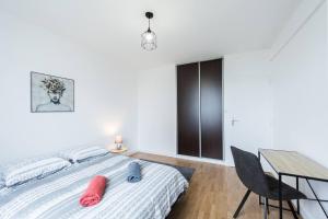 a bedroom with a bed and a desk and a table at Évadez-vous au cœur de Tours dans un appartement spacieux offrant une vue paisible sur des jardins luxuriants. in Tours