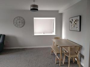 a dining room with a table and chairs and a window at Parkside Apartment Normanton in Wakefield
