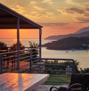 una casa con vistas al océano al atardecer en Belvedere Hotel & Suites, en Himare