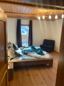1 dormitorio con 1 cama y 1 sofá azul en Appartement Erika en Flattach