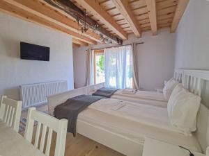 Un dormitorio con una cama grande y una ventana en Haus Rether - Transylvanian Guesthouse en Buneşti