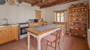 a kitchen with a table and chairs and a stove at Haus Rether - Transylvanian Guesthouse in Buneşti