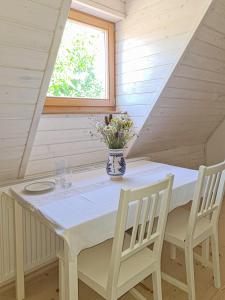 una mesa con dos sillas y un jarrón de flores. en Haus Rether - Transylvanian Guesthouse en Buneşti